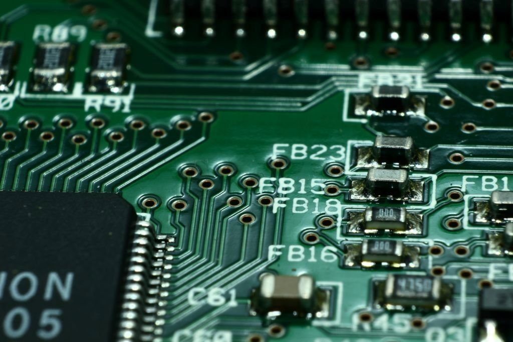 Close-up view of integrated circuit socket on green PCB showing pin connections and mounting holes